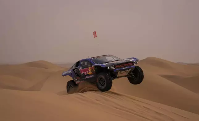 Driver Carlos Sainz and co-driver Lucas Cruz compete during the tenth stage of the Dakar Rally between Wadi Ad Dawasir and Bisha, Saudi Arabia, Wednesday, Jan.14, 2026. (AP Photo/Thibault Camus)