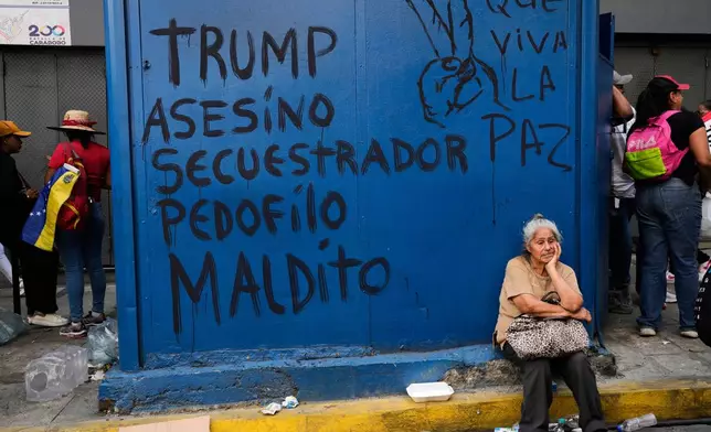 Graffiti that reads in Spanish, "Trump: murderer, kidnapper, pedophile, damned," left, and "Long live peace," covers a kiosk during a march to demand President Nicolas Maduro's return, in Caracas, Venezuela, Tuesday, Jan. 6, 2026, three days after U.S. forces captured him and his wife. (AP Photo/Matias Delacroix)