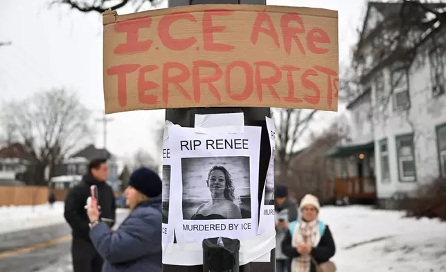 People gather around a makeshift memorial honoring the victim of a fatal shooting involving federal law enforcement agents, near the site of the shooting, Thursday, Jan. 8, 2026, in Minneapolis. (AP Photo/Tom Baker)