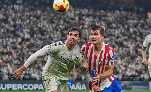 Real Madrid's Raul Asencio, left, duels for the ball with Atletico Madrid's Alexander Sorloth during the Spanish Super Cup semifinal soccer match at King Abdullah Sports City Stadium in Jeddah, Saudi Arabia, Thursday, Jan. 8, 2026. (AP Photo/Altaf Qadri)