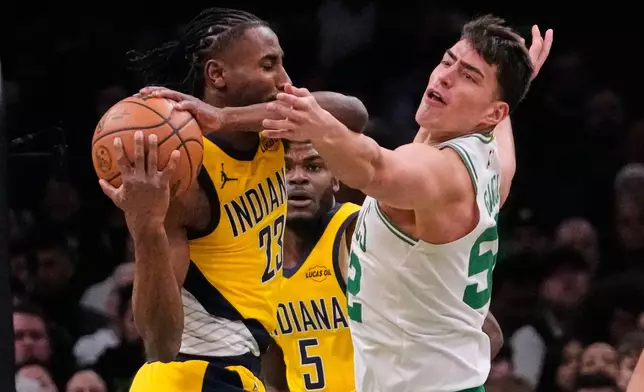 Boston Celtics center Luka Garza (52) pressures Indiana Pacers guard Aaron Nesmith (23) during the first half of an NBA basketball game, Wednesday, Jan. 21, 2026, in Boston. (AP Photo/Charles Krupa)