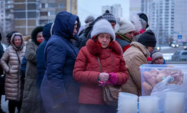 People who have no power at home following Russia's air attacks wait in line to receive free hot meals in a residential neighbourhood in Kyiv, Ukraine, Friday, Jan. 30, 2026. (AP Photo/Dan Bashakov)