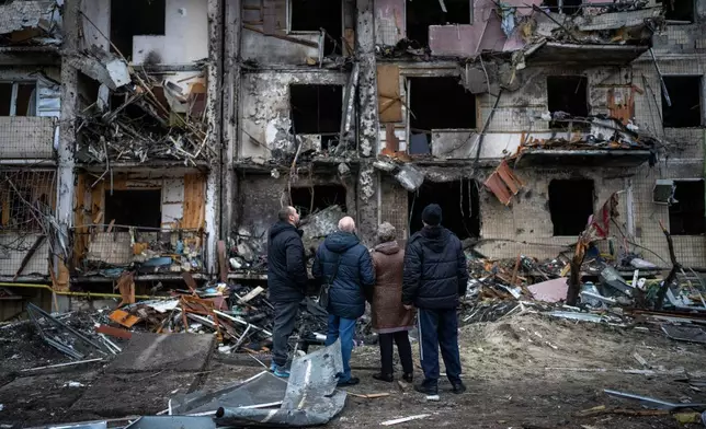 FILE- People look at the damage following a rocket attack the city of Kyiv, Ukraine, Feb. 25, 2022. (AP Photo/Emilio Morenatti, File)