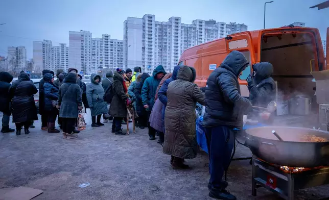 People who have no power at home following Russia's air attacks wait in line to receive free hot meals in a residential neighbourhood in Kyiv, Ukraine, Friday, Jan. 30, 2026. (AP Photo/Dan Bashakov)