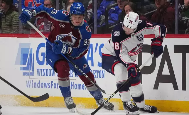 Columbus Blue Jackets defenseman Damon Severson, right, collects the puck as Colorado Avalanche center Zakhar Bardakov defends in the first period of an NHL hockey game Saturday, Jan. 10, 2026, in Denver. (AP Photo/David Zalubowski)