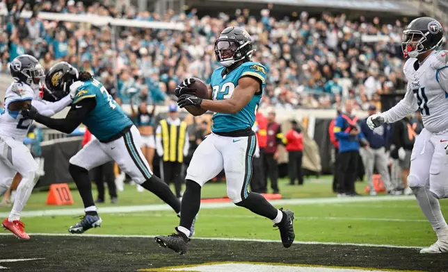 Jacksonville Jaguars running back Bhayshul Tuten (33) runs the ball into the end zone for a touchdown during the second half of an NFL football game against the Tennessee Titans, Sunday, Jan. 4, 2026, in Jacksonville, Fla. (AP Photo/Phelan M. Ebenhack)