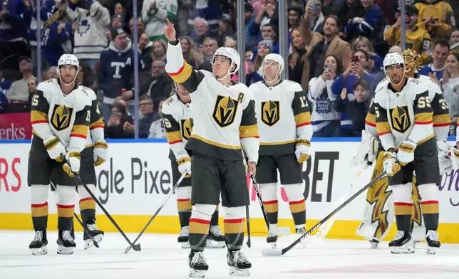 Vegas Golden Knights' Mitch Marner, center, waves to the crowd as they have a tribute to him while playing against his former team, the Toronto Maple Leafs, during first-period NHL hockey game action in Toronto, Friday, Jan. 23, 2026. (Nathan Denette/The Canadian Press via AP)