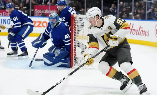 Vegas Golden Knights' Mitch Marner (93) tries a wrap around on Toronto Maple Leafs goaltender Anthony Stolarz (41) during third period NHL hockey action in Toronto on Friday, Jan. 23, 2026. (Nathan Denette/The Canadian Press via AP)