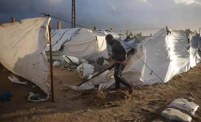 Khaled Abu Jazar, 53, reinforces his tent after it was damaged by stormy weather at a tent camp in Deir al-Balah, in the central Gaza Strip, Friday, Jan. 9, 2026. (AP Photo/Abdel Kareem Hana)