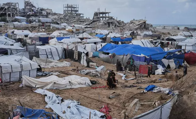 Palestinians inspect damaged tents at a displacement camp following an Israeli strike in Gaza City, Friday, Jan. 9, 2026. (AP Photo/Jehad Alshrafi)
