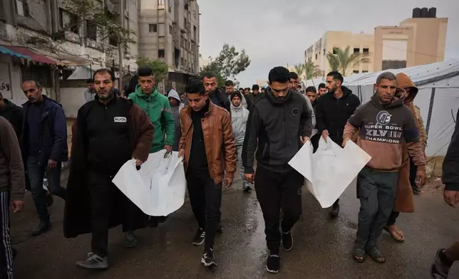 Mourners carry the bodies of Palestinians killed in an Israeli military strike, at Nasser Hospital in Khan Younis, Gaza Strip, Friday, Jan. 9, 2026. (AP Photo/Abdel Kareem Hana)