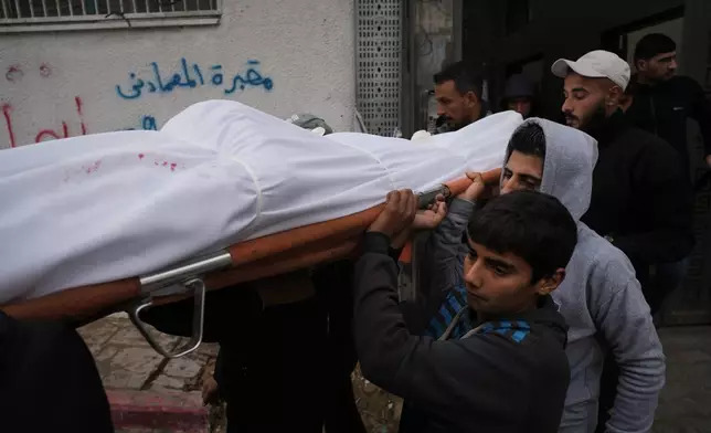 Mourners carry the body of Ibrahim Subh who was killed in an Israeli army strike, at Shifa Hospital in Gaza City, Friday, Jan. 9, 2026. (AP Photo/Jehad Alshrafi)