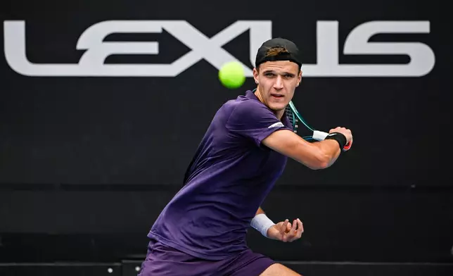 Jakub Mensik of the Czech Republic hits a forehand return to Sebastian Baez of Argentina in the men's singles final of the ASB Classic in Auckland, New Zealand, Saturday, Jan. 17, 2026. (Alan Lee/ Photosport via AP)