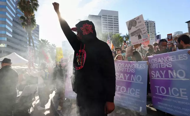 A protester gestures during a demonstration calling for an end to federal immigration enforcement operations and U.S. attacks on Venezuela, Saturday, Jan. 10, 2026, in Los Angeles. (AP Photo/Jill Connelly)