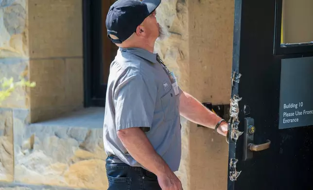 FILE - An official looks at damage around a door leading to university president Richard Saller's office at Stanford University in Palo Alto, Calif., June 5, 2024. (AP Photo/Nic Coury, File)