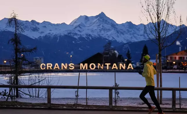 A man runs in the early morning in Crans-Montana, Swiss Alps, Switzerland, Saturday, Jan. 3, 2026, where a devastating fire in the Le Constellation bar left dead and injured during the New Year's celebrations. (AP Photo/Baz Ratner)