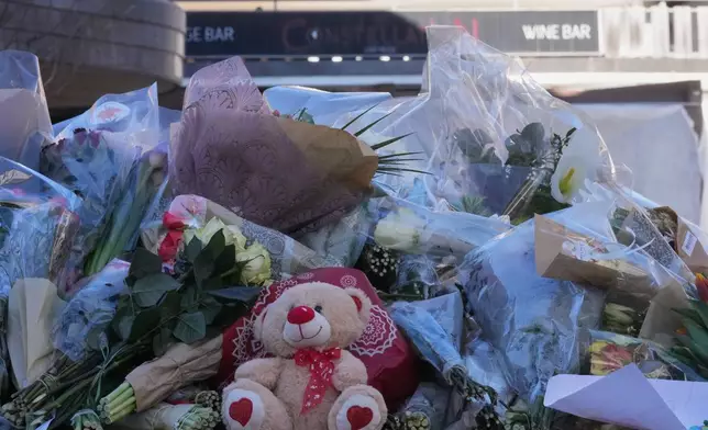 Flowers are placed in front of the sealed off Le Constellation bar in Crans-Montana, Swiss Alps, Switzerland, Saturday, Jan. 3, 2026, where a devastating fire left dead and injured during the New Year's celebrations. (AP Photo/Antonio Calanni)