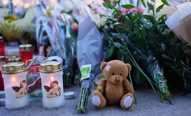 Candles and cuddly toys are placed near the sealed off Le Constellation bar in Crans-Montana, Swiss Alps, Switzerland, Saturday, Jan. 3, 2026, where a devastating fire left dead and injured during the New Year's celebrations. (AP Photo/Baz Ratner)