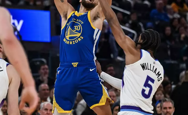 Golden State Warriors guard Stephen Curry (30) is fouled by Utah Jazz forward Cody Williams (5) during the first half of an NBA basketball game, Saturday, Jan. 3, 2026, in San Francisco. (AP Photo/Justine Willard)