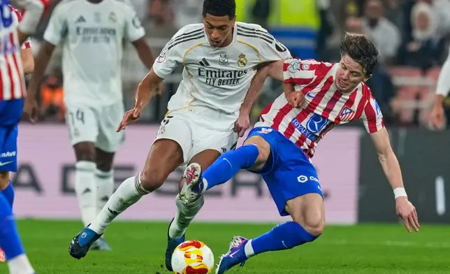 Atletico Madrid's Conor Gallagher, right, duels for the ball with Real Madrid's Jude Bellingham during the Spanish Super Cup semifinal soccer match at King Abdullah Sports City Stadium in Jeddah, Saudi Arabia, Thursday, Jan. 8, 2026. (AP Photo/Altaf Qadri)