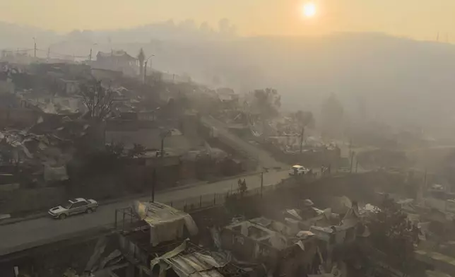The sun rises over homes damaged by wildfires in Lirquen, Chile, Sunday, Jan. 18, 2026. (AP Photo/Javier Torres)