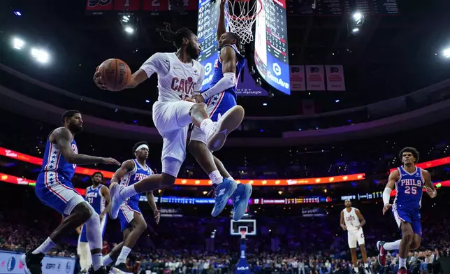 Cleveland Cavaliers' Darius Garland, left, passes against Philadelphia 76ers' Tyrese Maxey during the first half of an NBA basketball game Wednesday, Jan. 14, 2026, in Philadelphia. (AP Photo/Matt Slocum)