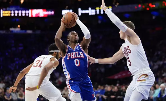 Philadelphia 76ers' Tyrese Maxey (0) goes up for a shot against Cleveland Cavaliers' Sam Merrill (5) during the first half of an NBA basketball game Wednesday, Jan. 14, 2026, in Philadelphia. (AP Photo/Matt Slocum)