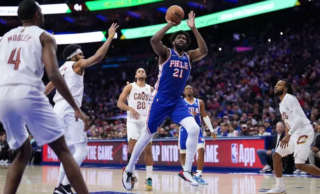 Philadelphia 76ers' Joel Embiid (21) goes up for a shot during the first half of an NBA basketball game against the Cleveland Cavaliers Wednesday, Jan. 14, 2026, in Philadelphia. (AP Photo/Matt Slocum)