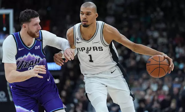 San Antonio Spurs forward Victor Wembanyama (1) drives around Utah Jazz center Jusuf Nurkic (30) during the first half of an NBA basketball game in San Antonio, Monday, Jan. 19, 2026. (AP Photo/Eric Gay)