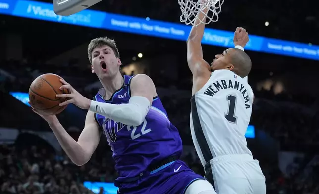 Utah Jazz forward Kyle Filipowski (22) is fouled by San Antonio Spurs forward Victor Wembanyama (1) during the second half of an NBA basketball game in San Antonio, Monday, Jan. 19, 2026. (AP Photo/Eric Gay)
