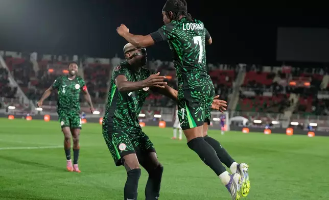 Nigeria's Victor Osimhen, center, celebrates with Nigeria's Ademola Lookman, right, after scoring his side's third goal during the Africa Cup of Nations round of 16 soccer match between Nigeria and Mozambique in Fez, Morocco, Monday, Jan. 5, 2026. (AP Photo/Themba Hadebe)