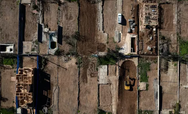 An aerial view shows houses being rebuilt on cleared lots months after the Palisades Fire, Dec. 5, 2025, in the Pacific Palisades neighborhood of Los Angeles. (AP Photo/Jae C. Hong)