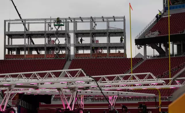 Workers build a structure above grow lights on the field at Levi's Stadium as it is prepared for the NFL's Super Bowl LX football game in Santa Clara, Calif., Tuesday, Jan. 20, 2026. (AP Photo/Jeff Chiu)