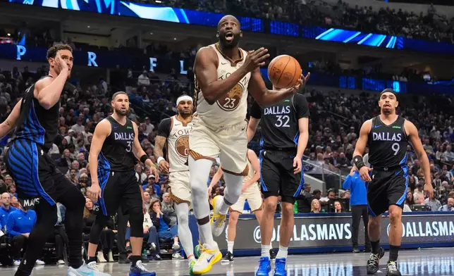 Golden State Warriors forward Draymond Green (23) is fouled driving to the basket by Dallas Mavericks' Dwight Powell, left, and Klay Thompson, Cooper Flagg (32) and Ryan Nembhard (9) look on in the first half of an NBA basketball game in Dallas, Thursday, Jan. 22, 2026. (AP Photo/Tony Gutierrez)