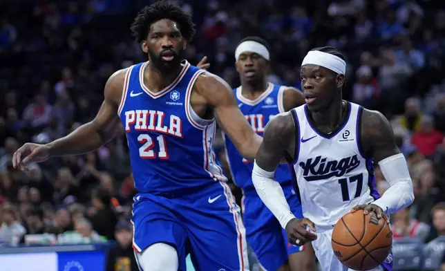 Sacramento Kings' Dennis Schroder, right, tries to get past Philadelphia 76ers' Joel Embiid during the first half of an NBA basketball game Thursday, Jan. 29, 2026, in Philadelphia. (AP Photo/Matt Slocum)