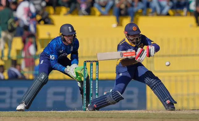 Sri Lanka's Kusal Mendis plays a shot as England's Jos Butler watches during the first ODI cricket match between England and Sri Lanka in Colombo, Sri Lanka, Thursday, Jan. 22, 2026. (AP Photo/Eranga Jayawardena)