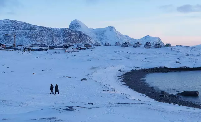 People walk on a beach in Nuuk, Greenland, on Thursday, Jan. 15, 2026. (AP Photo/Evgeniy Maloletka)