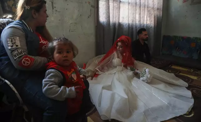 A Syrian bride displaced from the town of Al-Tabqa in northern Syria attends her wedding ceremony inside a classroom at a school being used as a shelter following clashes between Syrian government forces and the Kurdish-led Syrian Democratic Forces in Qamishli, northeastern Syria, Monday, Jan. 26, 2026. (AP Photo/Baderkhan Ahmad)