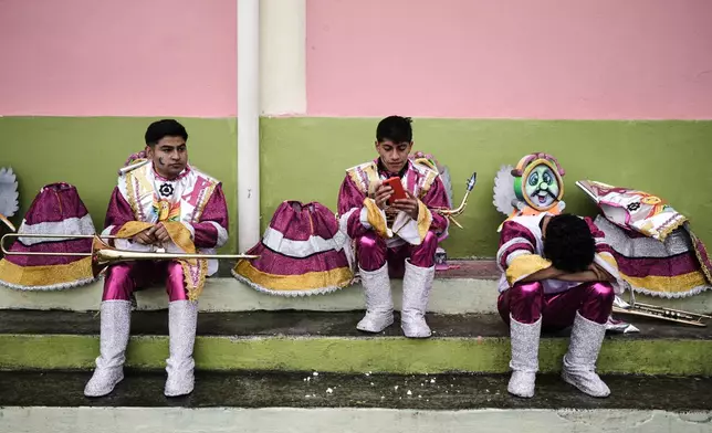 Revelers rest prior to the start of the Black and White Carnival, recognized by UNESCO as Intangible Cultural Heritage, in Pasto, Colombia, Tuesday, Jan. 6, 2026. (AP Photo/Ivan Valencia)
