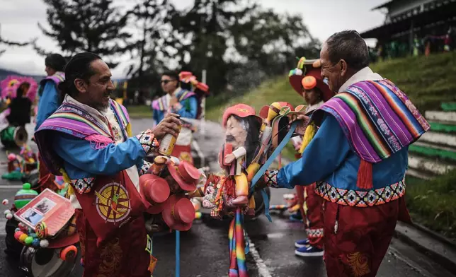 Revelers get their costumes and props ready for the start of the Black and White Carnival, recognized by UNESCO as Intangible Cultural Heritage, in Pasto, Colombia, Tuesday, Jan. 6, 2026. (AP Photo/Ivan Valencia)