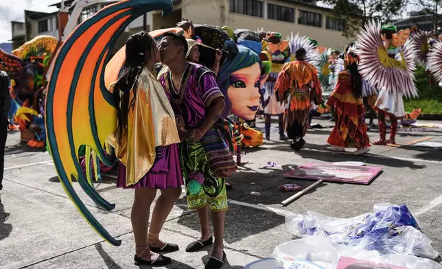 Revelers kiss prior to the start of the Black and White Carnival, recognized by UNESCO as Intangible Cultural Heritage, in Pasto, Colombia, Tuesday, Jan. 6, 2026. (AP Photo/Ivan Valencia)