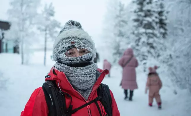People walk in freezing temperatures in Ylläs, Finland, Friday, Jan. 9, 2026. (Satu Renko/Lehtikuva via AP)