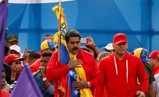 FILE - Venezuela's President Nicolas Maduro embraces a national flag during a rally in Caracas, Venezuela, July 27, 2017. Maduro provoked international outcry and enraged an opposition demanding his resignation with his push to elect an assembly that will rewrite the nation's constitution. (AP Photo/Ariana Cubillos, File)