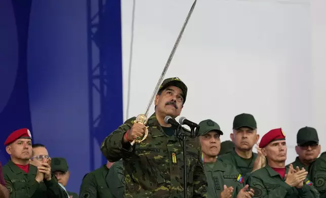 FILE - Venezuelan President Nicolas Maduro brandishes a sword said to have belonged to independence hero Simon Bolivar during a civic-military event at the military academy in Caracas, Venezuela, Nov. 25, 2025. (AP Photo/Ariana Cubillos, File)