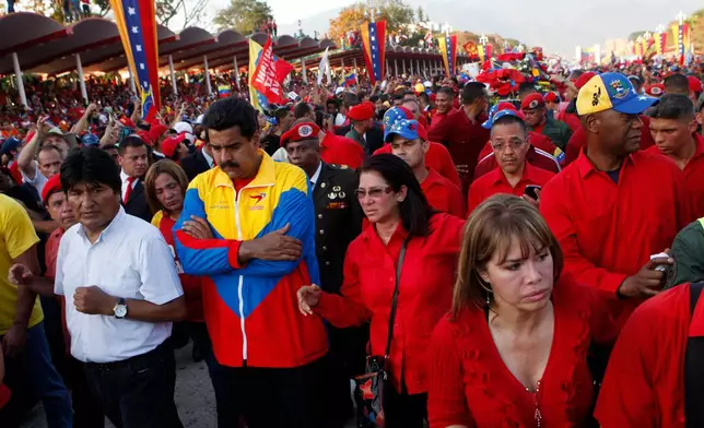 FILE - Bolivia's President Evo Morales, front left, Venezuela's Vice President Nicolas Maduro, second from left, and Attorney General Cilia Flores, third from left, walk in the procession carrying the coffin of Venezuela's late President Hugo Chavez from the hospital where he died, to the military academy where his body will lie in state in Caracas, Venezuela, March 6, 2013. (AP Photo/Esteban Felix, File)