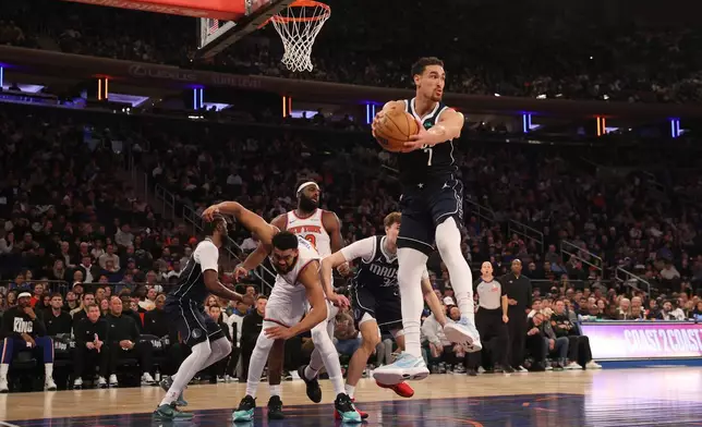 Dallas Mavericks' Dwight Powell (7) catches a rebound shot by New York Knicks' Karl-Anthony Towns, front left, during the first half of an NBA basketball game, Monday, Jan. 19, 2026, in New York. (AP Photo/Pamela Smith)