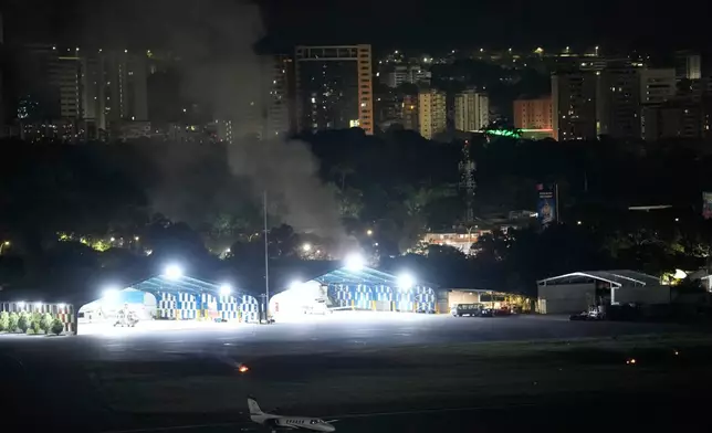 Smoke raises at La Carlota airport after explosions and low-flying aircraft were heard in Caracas, Venezuela, Saturday, Jan. 3, 2026. (AP Photo/Matias Delacroix)