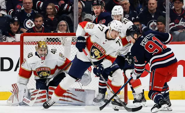 Florida Panthers' Niko Mikkola (77) defends against Winnipeg Jets' Cole Perfetti (91) the first period of an NHL hockey game in Winnipeg, Thursday, Jan. 22, 2026. (John Woods/The Canadian Press via AP)