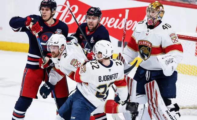 Florida Panthers' Jeff Petry (2) and Tobias Bjornfot (22) defend against Winnipeg Jets' Morgan Barron (36) and Tanner Pearson (70) during second-period NHL hockey game action in Winnipeg, Manitoba, Thursday, Jan. 22, 2026. (John Woods/The Canadian Press via AP)