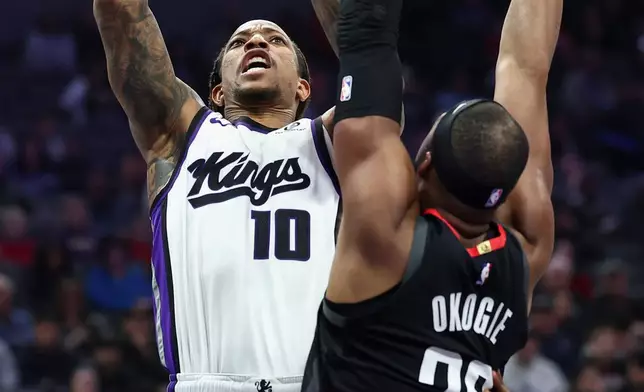 Sacramento Kings guard DeMar DeRozan (10) shoots over Houston Rockets guard Josh Okogie (20) during the first half of an NBA basketball game, Sunday, Jan. 11, 2026, in Sacramento, Calif. (AP Photo/Sara Nevis)